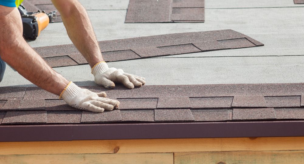 Roofer builder worker installing roof shingles
