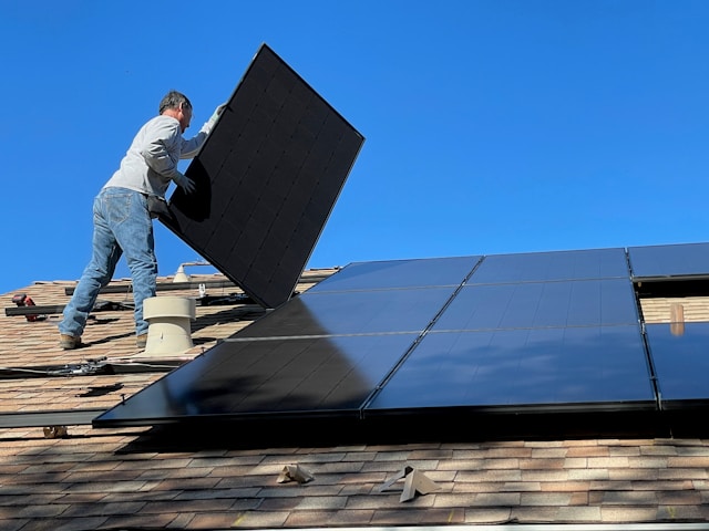Worker installing solar panels on a roof